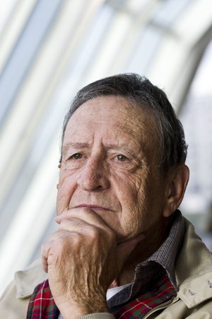 An older man sitting by window light thinking