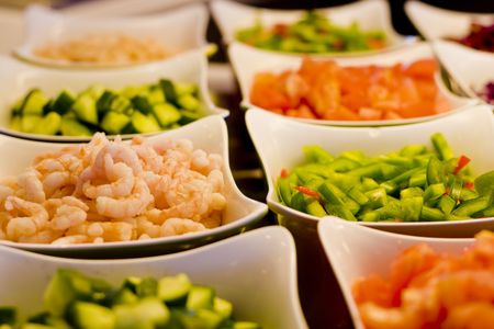 Cut vegetables and shrimp at a salad barの写真素材