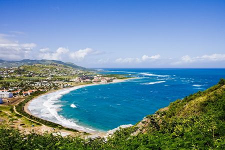 Deep Blue Sea and Green Hills under Blue Sky and Cloudsの写真素材
