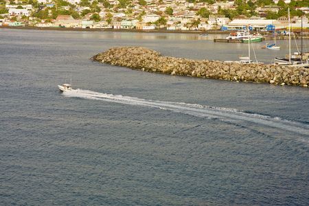 A fishing boat off the coast past a sea wallの写真素材