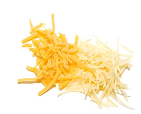 Fresh grated white and yellow cheeses on whiteの写真素材