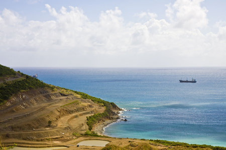 A freighter in the blue water off a coast stripped for constructionの写真素材