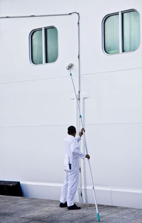 A worker scrubbing the side of a ship with a brushの写真素材