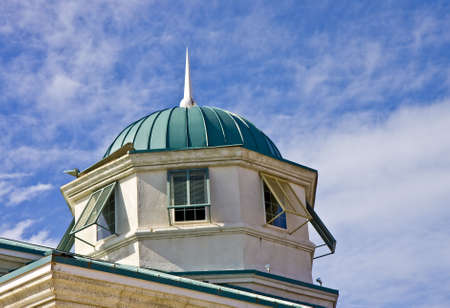 an old cupola with a green roof against a blue skyの写真素材