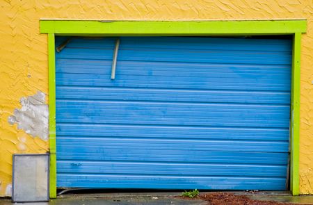A blue loading door on an old yellow buildingの写真素材