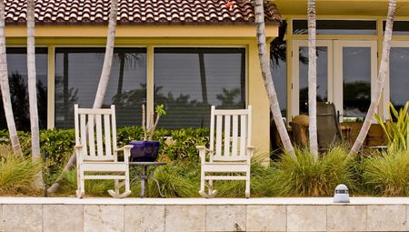 Two classic rocking chairs on the wall of a canalの写真素材