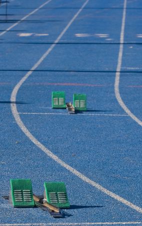 Green starting blocks in a lane of a blue trackの写真素材