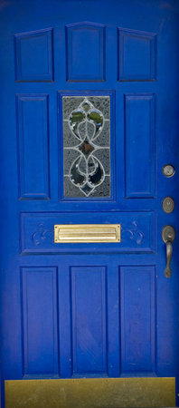 A bright blue door with ornate trim and hardware