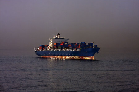 A freighter full of shipping containers in the night sea