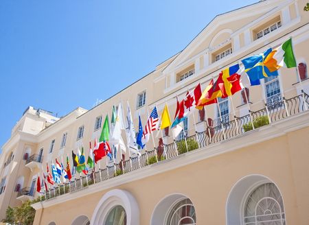 A beautiful hotel in Capri overlooking the sea with an array of flags over the front entranceの写真素材