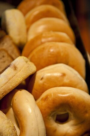 A bin full of fresh hot bagels in a marketの写真素材