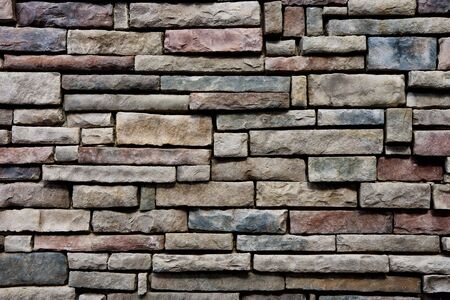 A multicolored stone wall good for backgrounds or texturesの写真素材