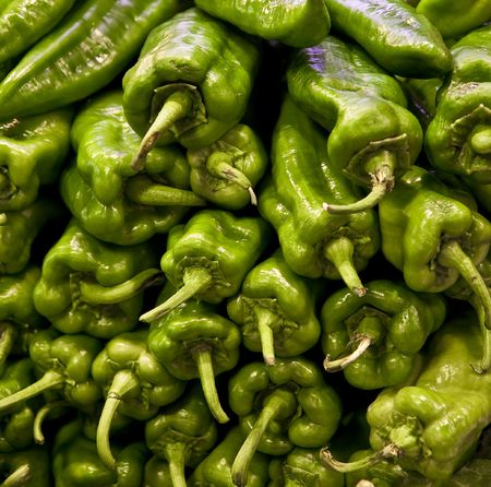 A stack of hot green peppers at a vegetable marketの写真素材