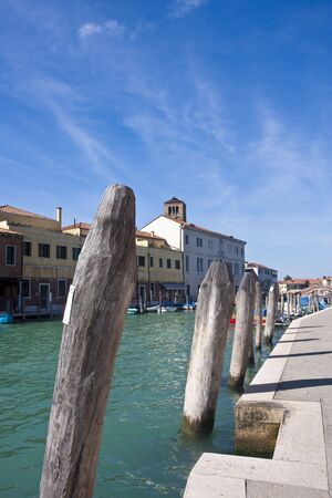 Old docking poles along a pier on the canal in Venice Italyの写真素材