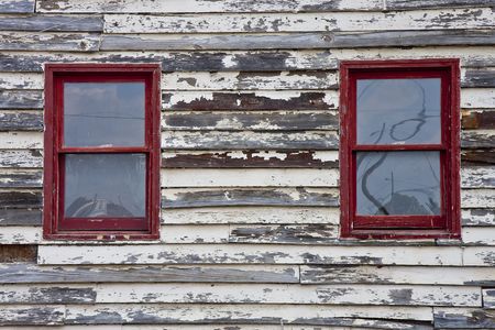 Two red windows in an old wall in need of paintの写真素材