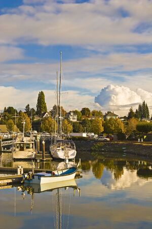 White sailboats at a marina with storm clouds in the distanceの写真素材