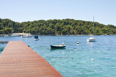 An old wooden pier into a crystal clear blue bayの写真素材