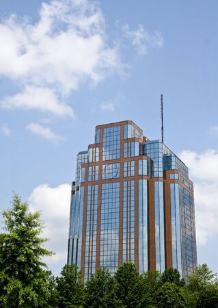 A nice modern red brick and glass office building rising out of the treesの写真素材