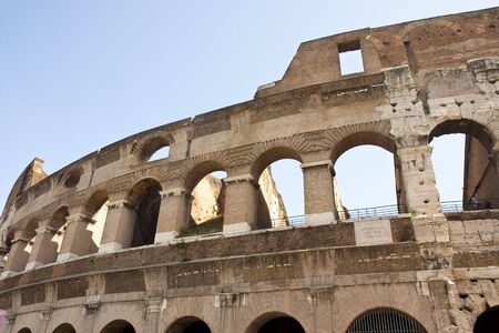 A view of the exterior of the ancient coliseum in Rome Italy against a clear blue skyの写真素材