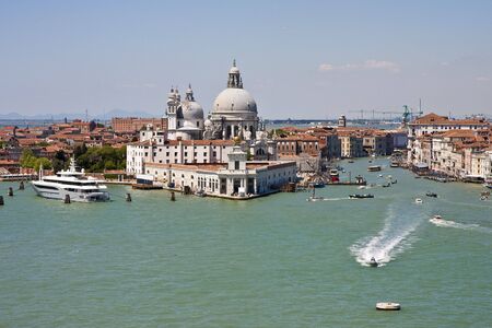 A view of the beautiful architecture, churches, and boats along the canals in Venice, Italyの写真素材