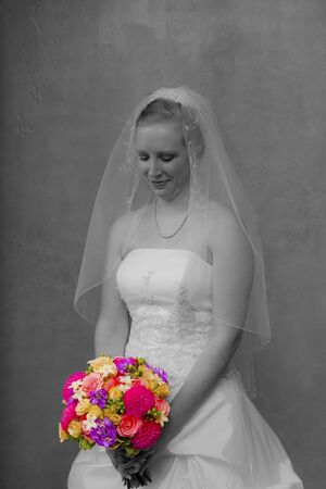 A beautiful young bride in her wedding gown with bouquetの写真素材