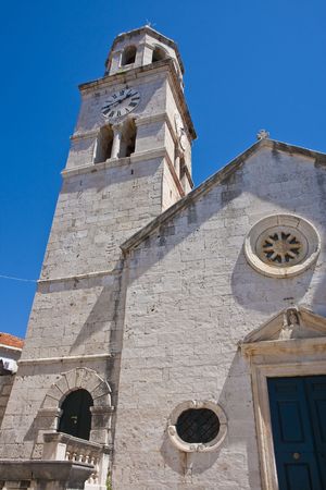 A clock tower on an old stone church against blue skyの写真素材
