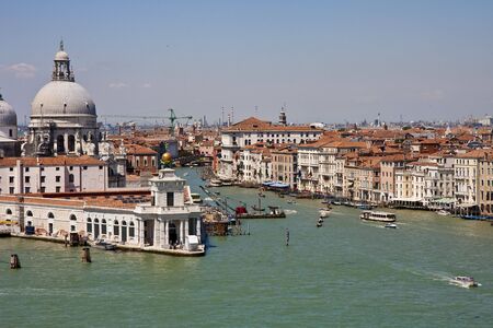 A view of the beautiful architecture, churches, and boats along the canals in Venice, Italyの写真素材