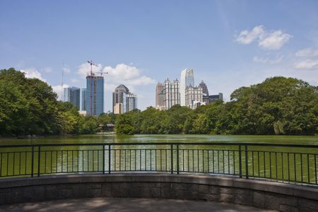 A view of the Atlanta Skyline shot from Piedmont Park with a small patio on the lakeの写真素材