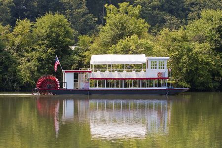A red and white river boat on a calm riverの写真素材