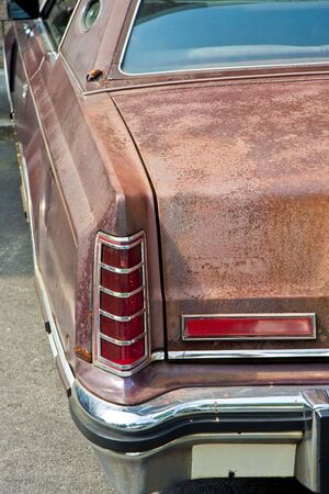 An old classic luxury sedan with a rusted bodyの写真素材