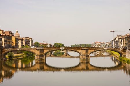 Beautiful bridge and reflection in the Arno River in Florence Italy shot from Ponte Vecchioの写真素材