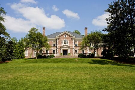 A large estate on top of a green grassy hillの写真素材