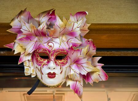 A colorful Venetian mask on the wall of a shopの写真素材