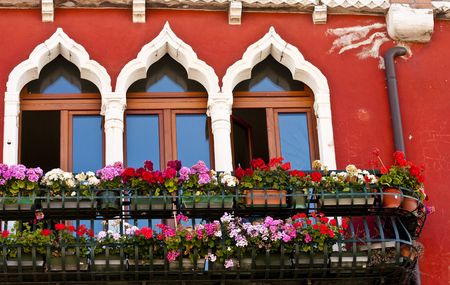 Colorful Flowers Under Window on a red building in Veniceの写真素材