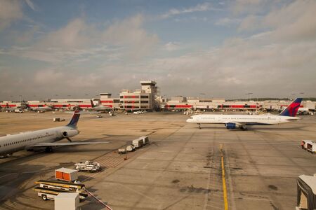 Airplanes waiting on tarmac at a busy commercial airportの写真素材
