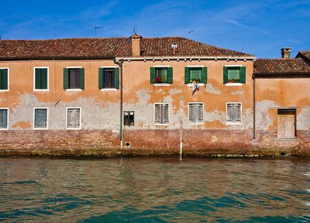 An old brick and stucco building on the Grand Canal in Venice Italyの写真素材