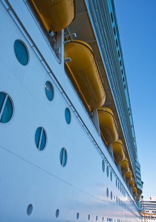 The side of a cruise ship with lifeboats and portholesの写真素材