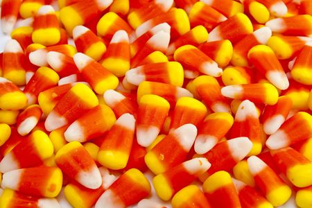 A colorful background of orange, yellow, and white candy corn for fall or halloweenの写真素材