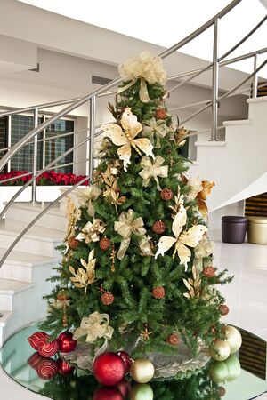 A decorated Christmas tree in a modern white and chrome lobbyの写真素材