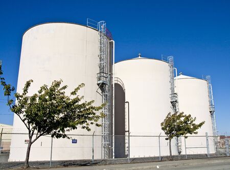 Thre white storage tanks against a blue skyの写真素材