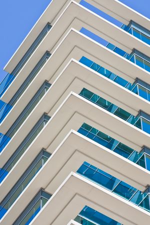 White corners of a modern blue building into the blue skyの写真素材