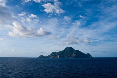 A green island rising from deep blue sea of the Caribbeanの写真素材