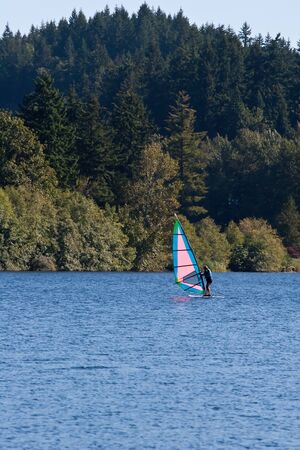 A pink and blue wind surfer on a blue lakeの写真素材