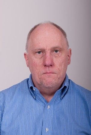 An older balding man in a blue shirtの写真素材
