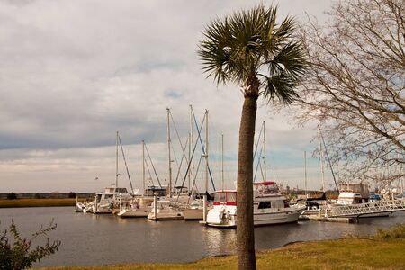 Boats tied up at a dock on a cloudy day in winterの写真素材