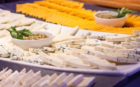 A selection of sliced cheeses on a salad barの写真素材