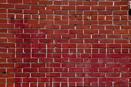 An old red brick wall stained and chippedの写真素材