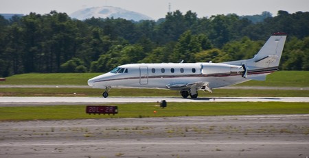 A large private jet landing on a regional runwayの写真素材