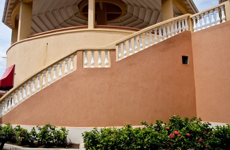 A curving staircase around a peach colored stucco buildingの写真素材