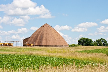 A road salt storage building in a field under blue skiesの写真素材